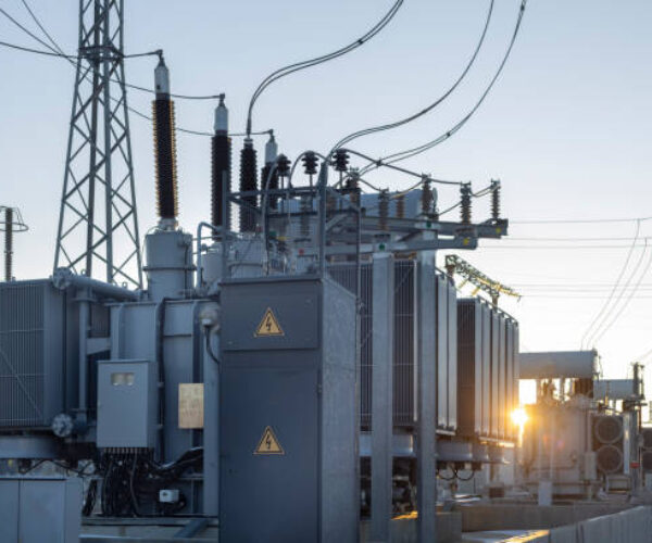 High-voltage transformer substation in winter at dawn. High voltage equipment. Energy transfer technology.